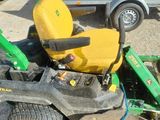 a lawn mower sitting on the ground next to a trailer