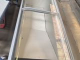 une porte vitrée située au milieu d'un tapis roulant dans une usine