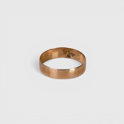 gros plan d'une bague en or sur fond blanc
