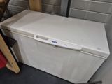 a white chest freezer sitting in the corner of a room
