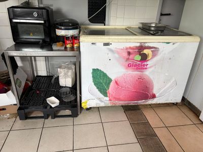 une photo d'une cuisine avec un réfrigérateur et un plan de travail