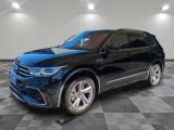 un SUV Volkswagen noir garé sur un sol à damier dans un showroom
