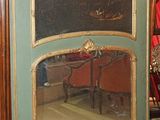 un grand miroir posé par terre à côté d'une chaise