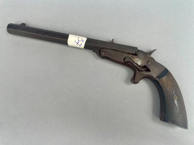un vieux pistolet muni d'une étiquette, posé sur une table