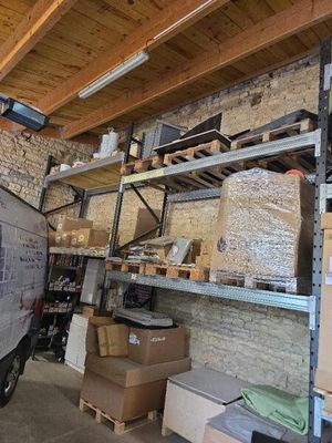 une camionnette garée dans un garage, avec des cartons sur les étagères