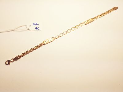 a close up of a gold bracelet with a chain attached to it
