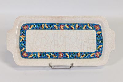 une image représentant un plat blanc orné d'une bordure bleue et de fleurs