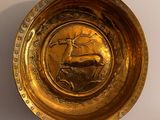 a gold plate with a picture of a deer on it