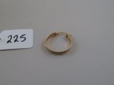 une petite bague en or et une étiquette posées sur une table