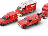 four toy ambulances and a fire truck on a white surface