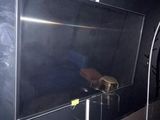 une télévision posée sur un meuble dans une pièce dont l'un des murs est noir