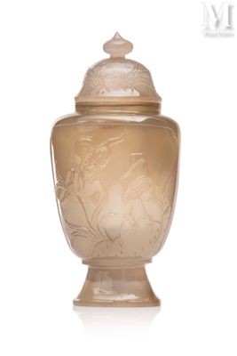 un vase en verre muni d'un couvercle, posé sur une surface blanche