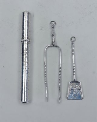 deux cuillères en argent, une cuillère et un repose-cuillère placés l'un à côté de l'autre