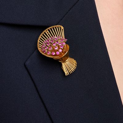 a close up of a brooch with pink flowers on it