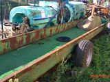 un tracteur garé dans l'herbe à côté d'une remorque