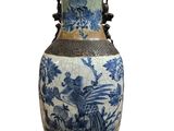 a blue and white vase with a bird and flowers on it