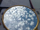 un miroir posé sur une table, dans lequel se reflète le ciel