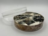 un gros plan d'un récipient métallique muni d'un couvercle, posé sur une surface blanche