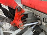 a close up of a machine with a red handle on it