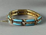 turquoise and gold bracelet with diamond accents on a gray surface