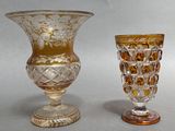 two glass vases sitting next to each other on a table