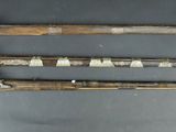 three old weapons are displayed on a table with a gray background