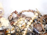 a white bowl filled with lots of assorted jewelry