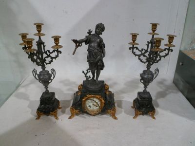 trois bougies et une horloge exposées dans une vitrine