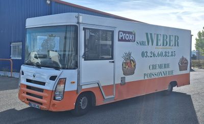 un camion de livraison garé devant un immeuble