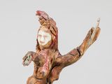 statue of a woman holding a bird in her hand on a wooden base