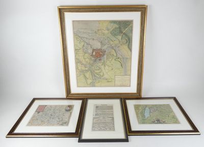 Trois cartes du monde encadrées sont accrochées sur un mur blanc