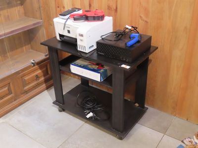 une petite table sur laquelle se trouvent une imprimante et d'autres appareils électroniques