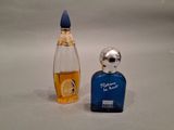 a small bottle of perfume next to a small bottle of perfume