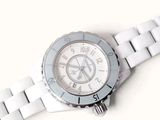 a close up of a white watch on a white surface