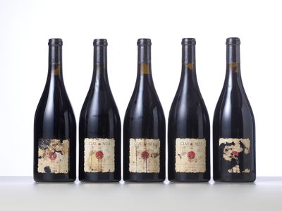 four bottles of wine are lined up on a table
