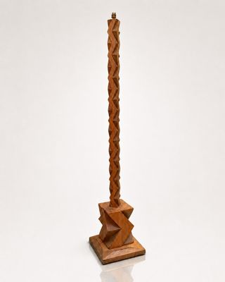 an image of a tall wooden candle holder with a candle on top