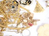 a pile of gold and silver jewelry on a white surface