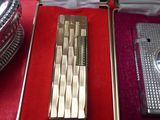 a silver lighter and a lighter case sitting on a red table