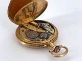 pocket watch on a white background with a key in the case