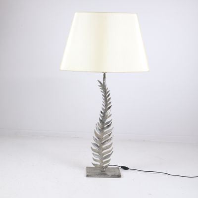 une lampe en forme de fougère argentée avec un abat-jour blanc sur fond blanc