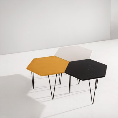 deux tables aux pieds noirs et une table jaune avec un plateau blanc