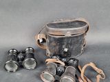 an old pair of binoculars sitting on top of a table next to a pair of glasses