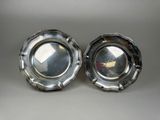 two silverplated dishes on a table with a white background