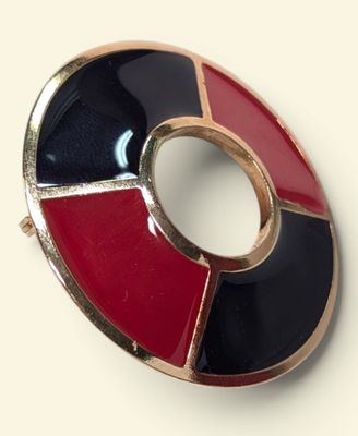 an image of a red, black and white broochle on a white surface