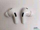 apple airpods with wireless earbuds on top of a white surface