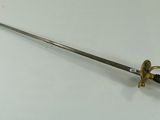 a close up of a sword on a table with a white background