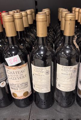 plusieurs bouteilles de vin sont alignées sur une étagère dans un magasin