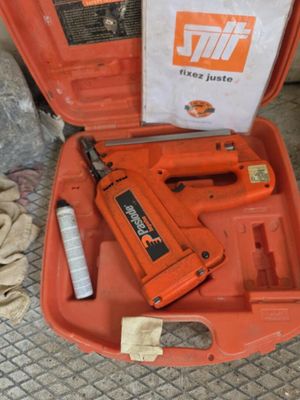 une boîte orange contenant des outils, posée par terre