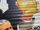 a large poster of a man holding a cup of coffee