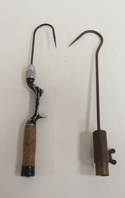 two fishing rods and a hook on a white surface
